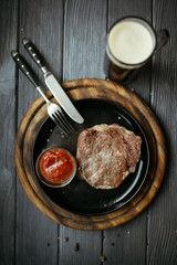 Delicious pork steak with peppers, solt and sauses. Meat and rosemary on wooden background.