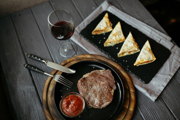 Delicious pork steak with peppers, solt and sauses. Meat and rosemary on wooden background.
