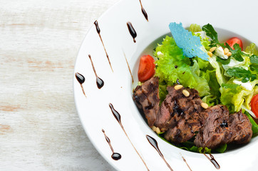 Vegetable salad with veal. Lettuce, veal, pine nuts, cherry tomatoes. Top view. Free space for your...