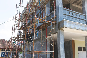 A worker constructing building standing on a scaffolding