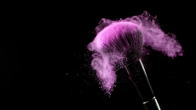 Super Slow Motion Shot of Pink Makeup Powder Falling from Facial Brush at 1000fps.