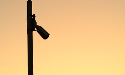 Silhouette of the Security camera on the pole on sunset..Space for text.