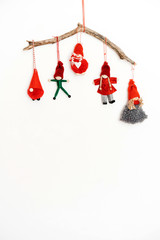 Wicked Christmas little men, snowmen and elves, made by hands from fabric and thread hanging on a wooden stick. New year creative concept of eco friendly decorations for the home.