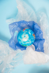 Ecology. The problem of pollution and debris on the planet. Small globe on plastic bags. Zero waste concept.