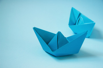Paper blue boats on a blue background. Place for text. Concept.