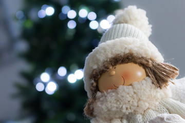 smiling baby girl with hat with illuminated christmas tree background