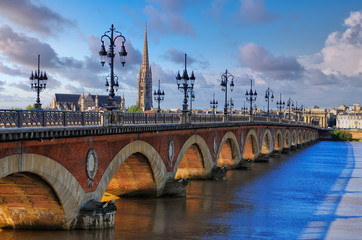 Plakat Scenic view of Bordeaux river bridge with St Michel cathedral, France