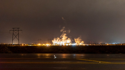 Industrial Plant in the Nighttime Casting Vapors Illuminated by Light