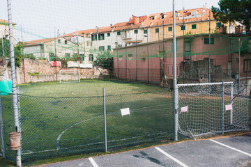 Small football field in between old houses in Italy