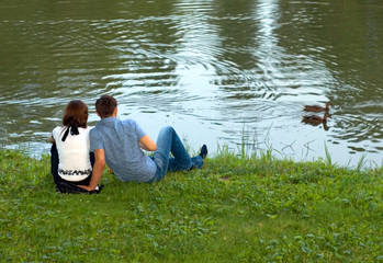 a young couple sit on the shore and look at the ducks  Установите приложение на смартфон и работайте офлайн  Переводите в Яндекс.Браузере