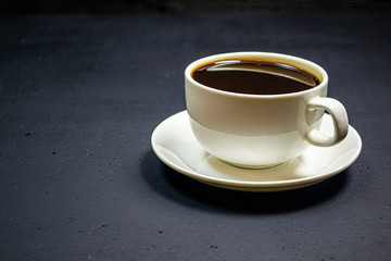 coffee in a white cup on a dark background