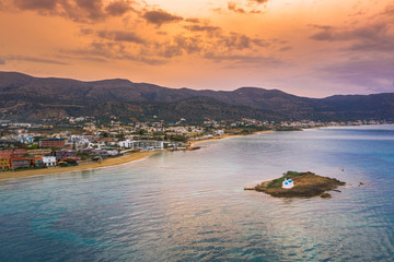 An old white church in a small island at sunset in Malia, Crete, Greece.