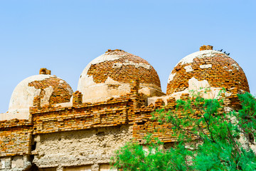 an ancient design of a mosque with tombs on the top of it made by traditional red bricks  