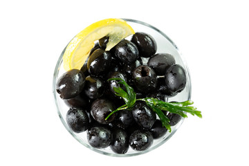 Black olives with lemon in a glass bowl. Top view. Isolated over white background.
