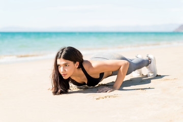 Woman Doing Push Ups On Beach