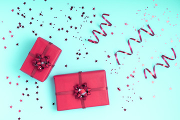 New Year and Christmas composition. Red christmas decorations - gift boxes on mint background. Top view, flat lay