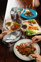 Group of people eating together and drinking wine in a restaurant top view