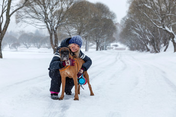 Fototapeta na wymiar Woman with a dog on a walk in snowy weather. Love and friendship.