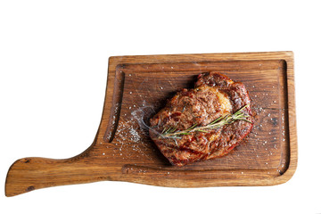 Appetizing meat steak with smoke on a wooden board. top view. Isolated over white background.