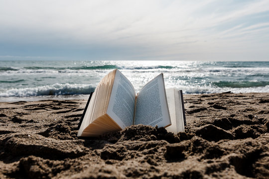 libro clásico abierto en el suelo, en la arena de la playa.