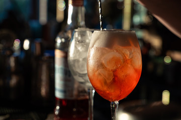 Making aperol spritz on bar counter with blurred background