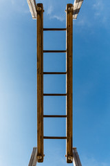 escalera de madera con el cielo de fondo. Columpio escalera de agilidad en parque infantil.