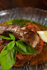 Chum salmon marinated in lemon juice with stewed vegetables on wooden table close up