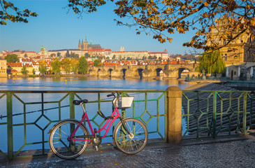 Prague - Le vélo de location sur le front de mer, le pont Charles, le château et la cathédrale en arrière-plan.