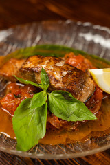 Close up of chum salmon marinated in lemon juice with stewed vegetables on wooden table