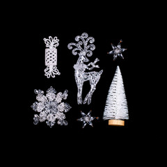 Chistmas white decorations on light blue background. Stars, deer, snowflake, pine and candies. Contrast ornamental concept. Top view. Flat lay.