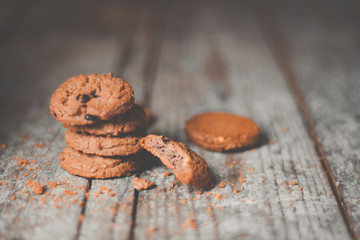 Chocolate cookies on wooden table. Chocolate chip cookies shot on coffee colored cloth, closeup, Brown tone concept 