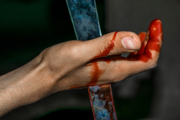 a sharp broken piece of glass dip into a hand and bleeding 