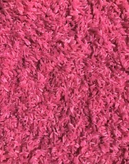 Rice background with granular details, texture. Pink raw uncooked rice close up shot. 
