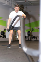 Strong man doing workout at the gym.
