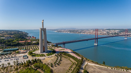 Aerial. Panorama from sky, a 25 de Abril Bridge and a statue of Jesus Christ. Lisbon.