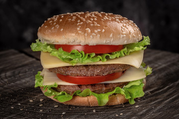 Popular American sandwich with meat and vegetables. On a wooden background.