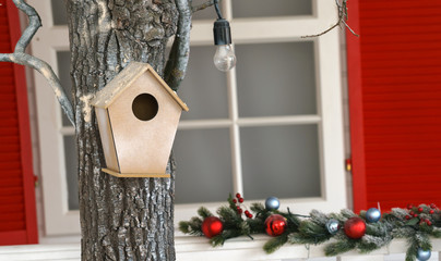 hanged Wooden bird house or nist on tree in decorated house garden