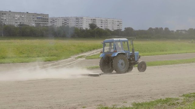 Wheeled tractor blue dub track racecourse old car tires.