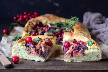 Homemade open pie with different types of cabbage, sauerkraut and cranberry on wooden tray. Selective focus, rustic style. Vegetarian food.