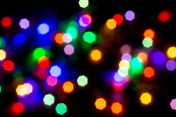 Christmas lights are lit on a black background. Copy the area for the top view text.