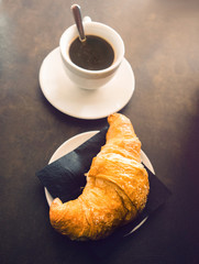 Italian espresso and croissant on a table