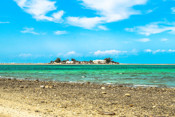 beautiful and bright pleasant day at a beach and an island in the background 