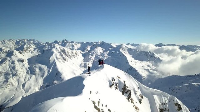 4k aerial orbit drone footage flying around  the snowy mountain peaks of Tartano Valley in Sondrio province, italian mountains in the central alps with presence of alpinists on top.