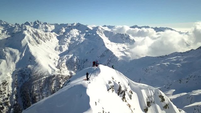 4k aerial orbit top down drone footage flying around  the snowy mountain peaks of Tartano Valley in Sondrio province, italian mountains in the central alps with presence of alpinists on top.