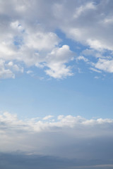 Clear blue sky between clouds in the bottom and top of image