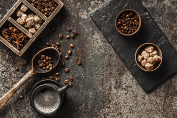 Coffee cup and coffee beans on dark stone background. Top view with copy space. Background with free text space.