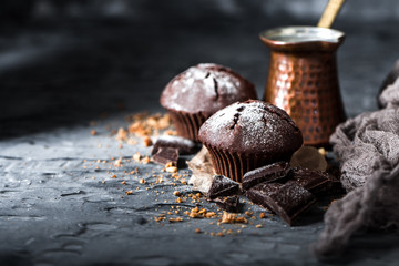 Muffin with coffee on dark textured background.