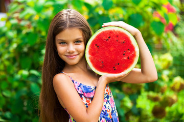 Portrait of a young little girl with watermelon