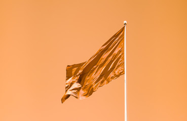waving orange flag on orange sky