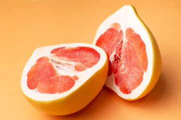 Fresh grapefruit on an orange background, close-up. Sex concept. The concept of women's health.